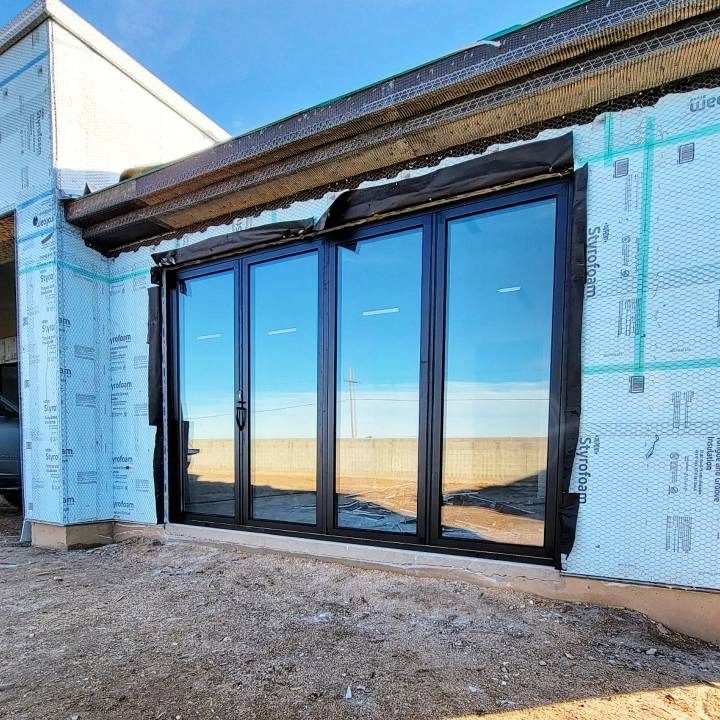 Large black framed folding glass doors installation